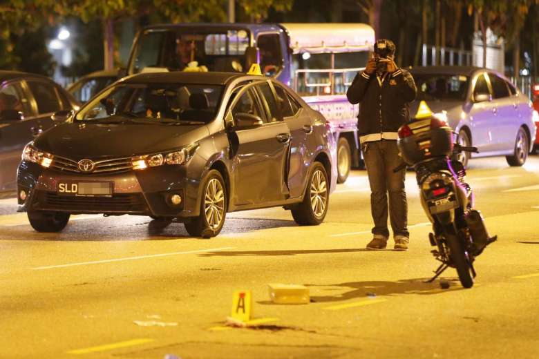 Crash scene of fatal dooring of motorcyclist on Singapore street after passenger opened car door into cyclist's path.