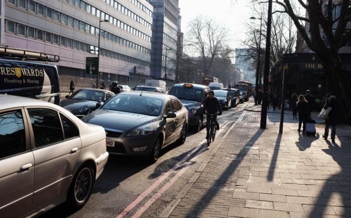 Photo of cyclist riding between curb & parked cars from AIPCR Italia post on Dutch Reach in Italian language.  Associzione Mondiale della Strata