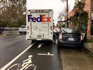 Driver doors Fedex truck traveling in bicycle lane.
