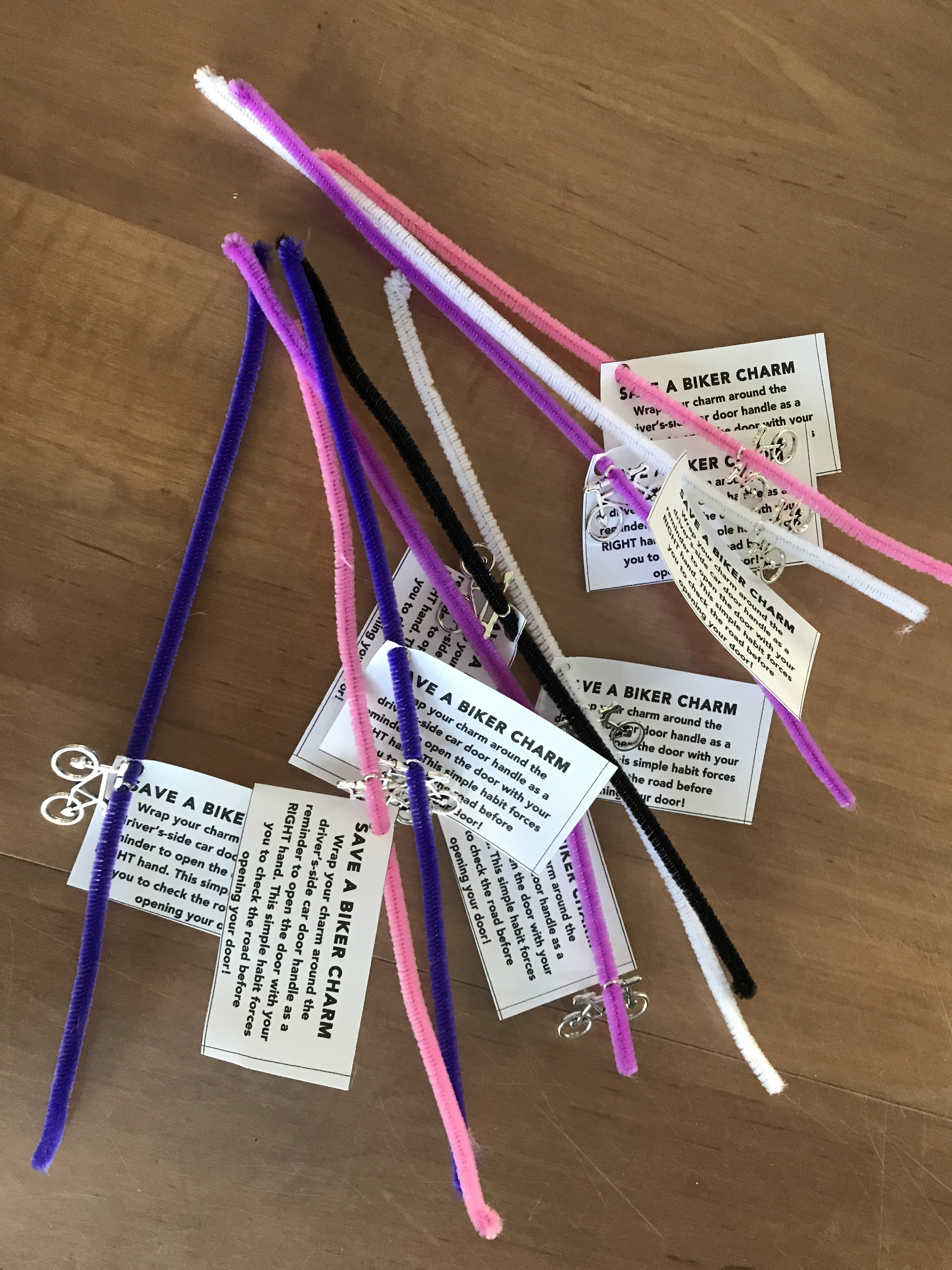 Examples of Dutch Reach reminders or aide de memoire made of a tag with Dutch reach text on paper, attached to pipe-cleaners.
